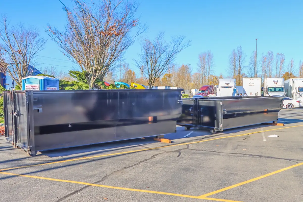 Professional dumpster rental service with roll-off container on residential driveway in Fort Bliss